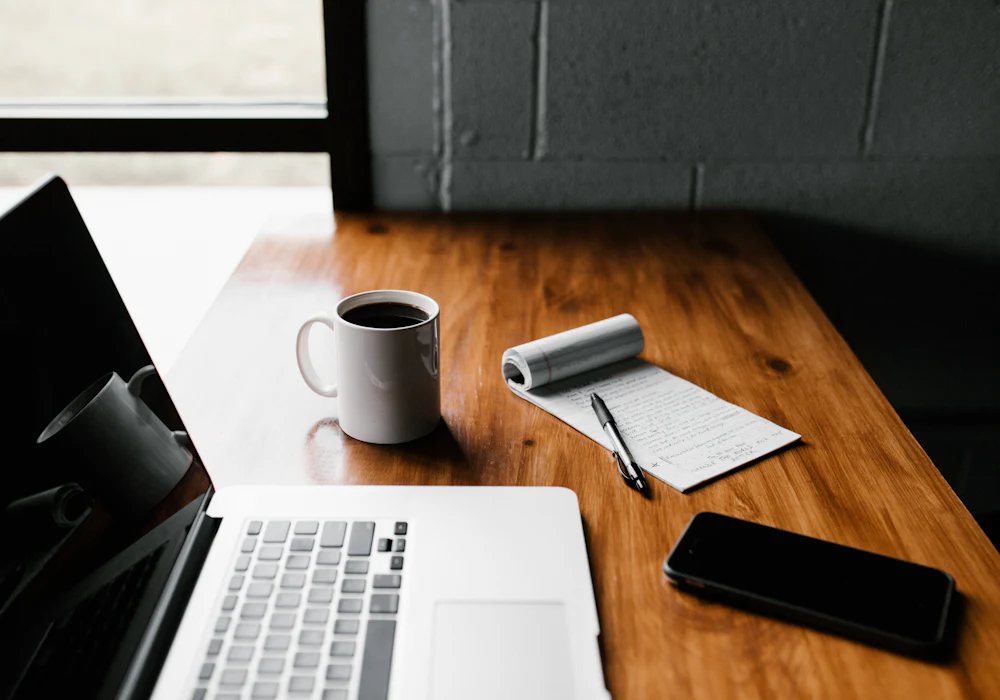 Sourcing desk with laptop, notebook and mug